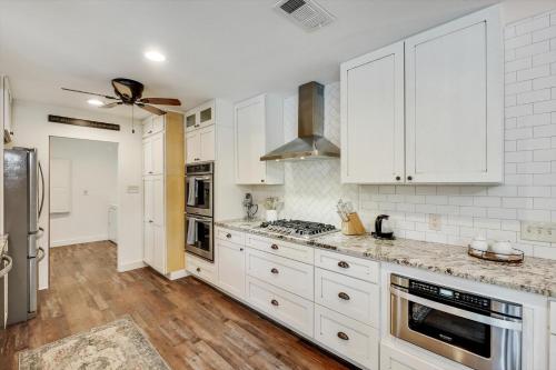 a kitchen with white cabinets and a stove top oven at Your Rustic Retreat w Backyard Oasis Pool Patio in Keller