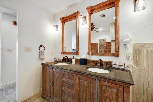 a bathroom with two sinks and a large mirror at Your Rustic Retreat w Backyard Oasis Pool Patio in Keller
