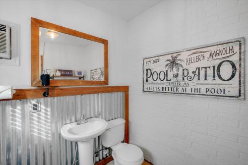 a bathroom with a sink and a toilet and a mirror at Your Rustic Retreat w Backyard Oasis Pool Patio in Keller