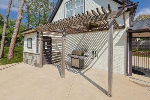 a barbecue under a wooden pergola in a backyard at Your Rustic Retreat w Backyard Oasis Pool Patio in Keller