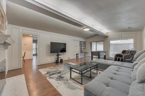 a living room with a couch and a tv at Spacious and Modern Home with Private Pool in Plano