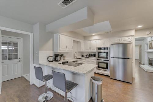 a kitchen with white cabinets and stainless steel appliances at Spacious and Modern Home with Private Pool in Plano