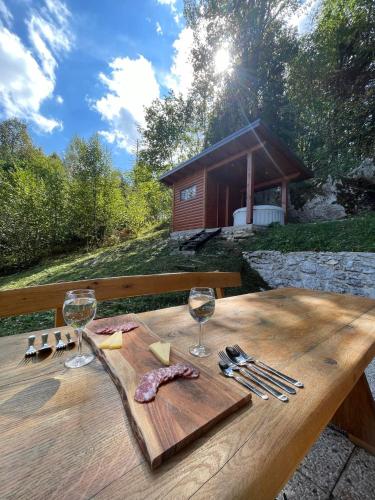 a wooden table with wine glasses and meat on it at Relax house AVUS with Sauna in Slappe dʼIdria