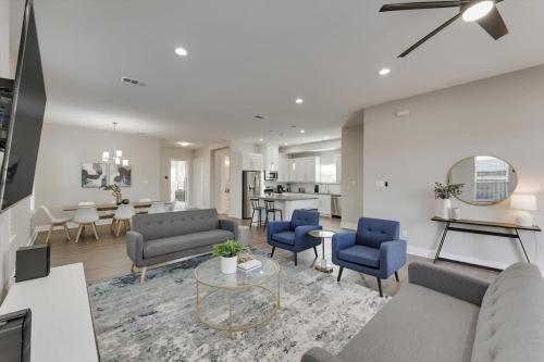 ein Wohnzimmer mit Sofa, Stühlen und einem Tisch in der Unterkunft Modern and Spacious High End Home near Downtown in Dallas