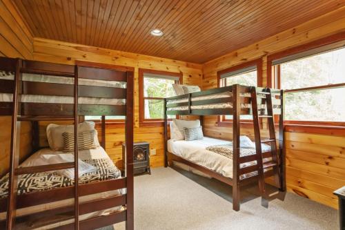 two bunk beds in a cabin with a fireplace at Serenity Summit in Banner Elk