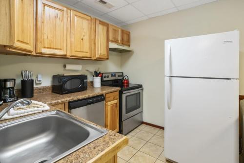 a kitchen with a sink and a white refrigerator at Serenity Summit in Banner Elk