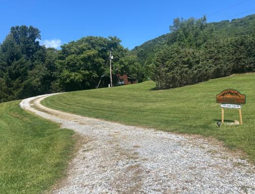 a gravel road with a sign on the side of a field at Serenity Summit in Banner Elk