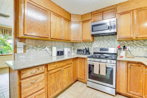 a kitchen with wooden cabinets and a stove and microwave at Pet-Friendly Home Near Downtown Henderson in Las Vegas