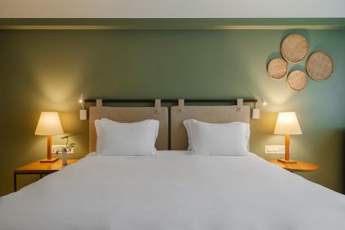 a bedroom with a large white bed with two lamps at Grand Mercure Rio de Janeiro Copacabana in Rio de Janeiro