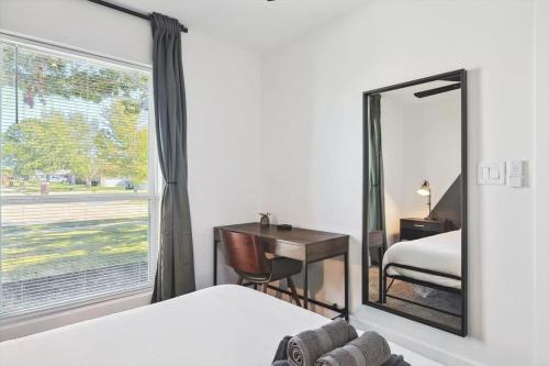 a bedroom with a mirror and a desk and a window at Paradise Modern Home Pool & Hot Tub for over 30 Nights in Waxahachie