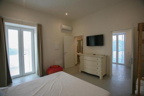 a bedroom with a bed and a dresser with a television at Il Carrubo in Procida