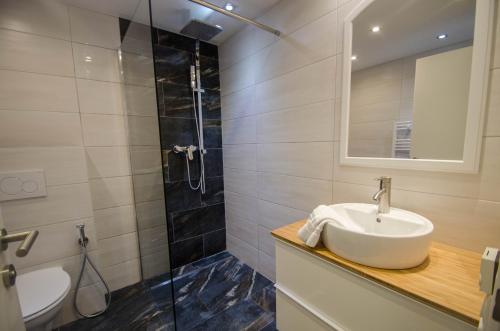 un bagno con lavandino e doccia di Appartement THE GOOD VIEW by All in One Apartments a Zell am See