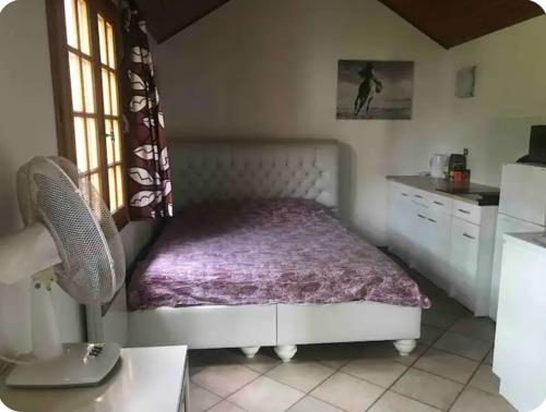 une petite chambre avec un lit et une cuisine dans l'établissement Studio pas loin de Disney 15 min en voiture, à Chanteloup-en-Brie