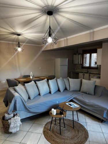 a living room with a blue couch and a table at DOLCE VITA LUXURY APARTMENT Markopoulo in Markopoulo