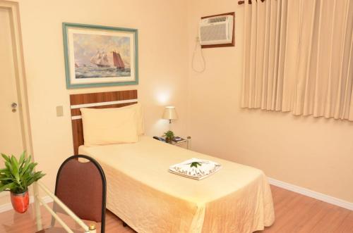 a room with a bed with a table with a napkin on it at Skalla Hotel Nova Odessa in Nova Odessa