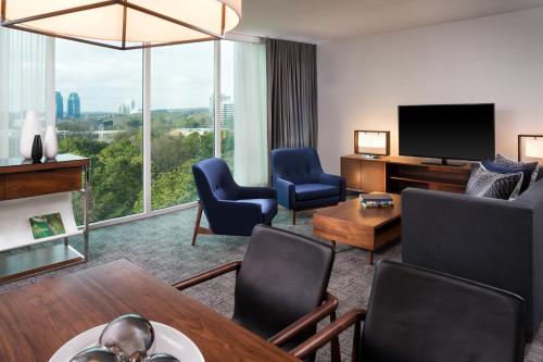 a living room with a couch and a tv at Le Meridien Atlanta Perimeter in Atlanta