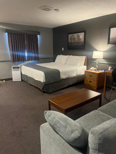 a hotel room with two beds and a couch at Travelodge by Wyndham Brandon in Brandon