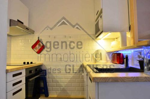 une cuisine avec un panneau mural dans l'établissement Résidence LES ROCHES - 4 Pièces pour 8 Personnes MAE-9794, à Aime La Plagne