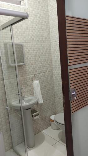 a small bathroom with a toilet and a sink at Pousada Jesus Misericordioso in Aparecida
