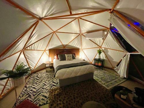 a bedroom in a dome tent with a bed in it at Glamping con jacuzzi en piso 15, único en Gdl, vistas espectactaculares in Guadalajara