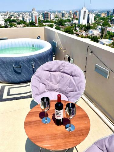 a table with two bottles of wine and two glasses at Glamping con jacuzzi en piso 15, único en Gdl, vistas espectactaculares in Guadalajara