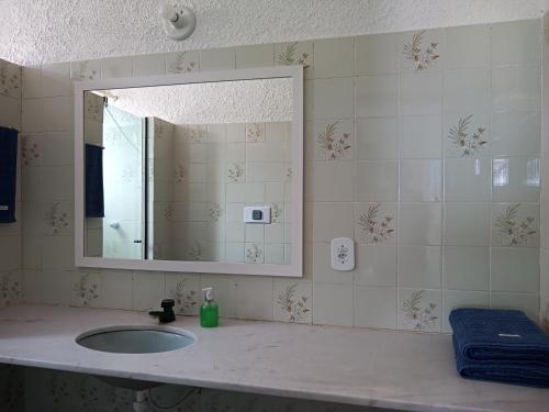 a bathroom with a sink and a mirror at Vista Mar Suítes in Cabo Frio