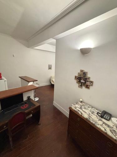 un salon avec une table et une chambre avec un bureau dans l'établissement Le Carmélite Toulouse-Centre, à Toulouse