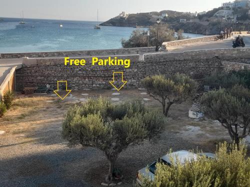 a retaining wall with trees and the words free parking at Με θέα τον όρμο της Βάρης in Vari