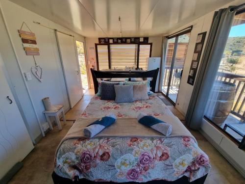 a bedroom with a large bed with flowers on it at Romantic Cottage in Barrydale