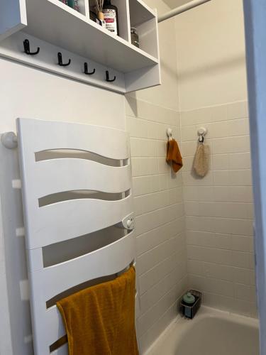 une salle de bain avec une baignoire blanche et un lavabo dans l'établissement Un charmant appartement à côté de la cité florale, à Paris