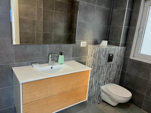 a bathroom with a sink and a toilet at Prince Palace Netanya Lagoon Beach 3BR in Netanya