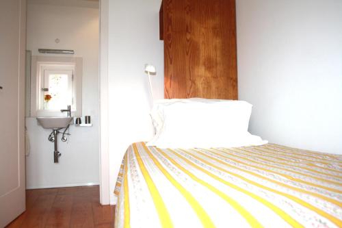 una camera con un letto con copriletto giallo e bianco di Casa da Cerca a Óbidos