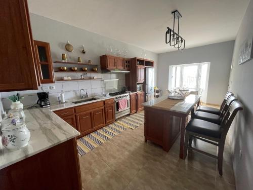 a kitchen with wooden cabinets and a table and a counter at Villa Vicente Casa Soares in Vila Nova Sintra