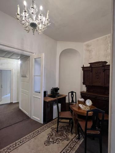 a living room with a table and a chandelier at Csaky palace 2 Bratislava in Bratislava