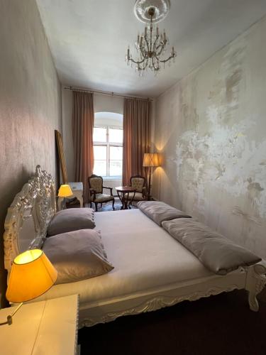 a bedroom with a large bed with a chandelier at Csaky palace 2 Bratislava in Bratislava