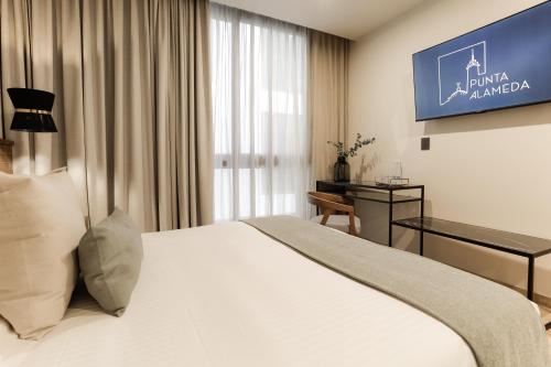 a hotel room with a bed and a tv at Punta Alameda in Mexico City