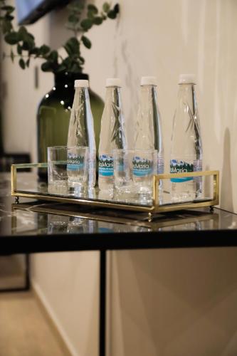 a tray with four bottles and glasses on a table at Punta Alameda in Mexico City