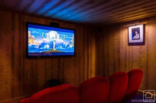 - une télévision dans une chambre dotée d'un mur en bois dans l'établissement Chalet grandiose au pied des pistes de Morzine - Vue imprenable, à Morzine
