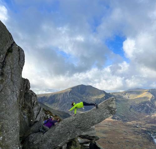 a person standing on the edge of a mountain at Red Dragon Cottages nr Mt Snowdon in Beddgelert