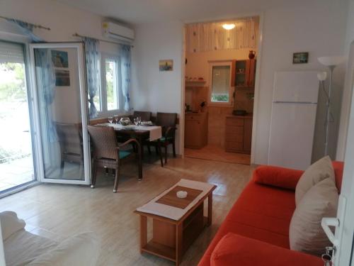 een woonkamer met een rode bank en een tafel bij Apartman Volarevic in Donji Karin
