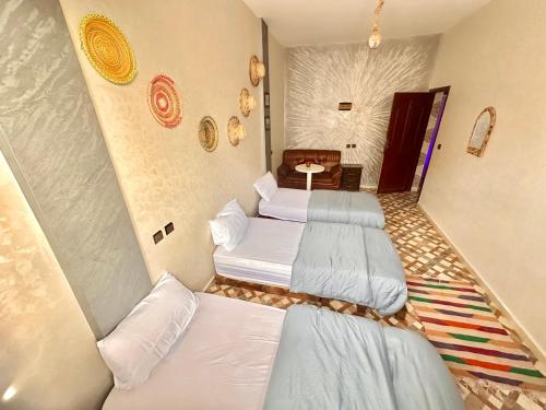 a room with three beds in a room at Imsouane Surf Slab Hostel in Imsouane
