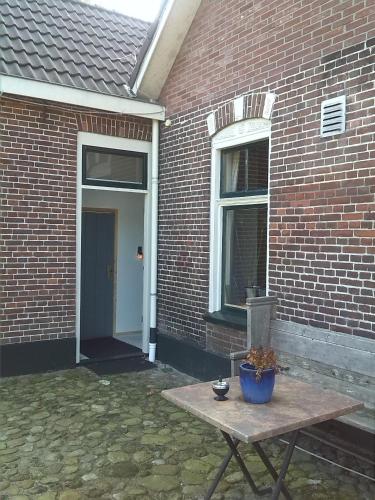 a picnic table in front of a brick building at B&B In De Backerije 2 in Zuidwolde