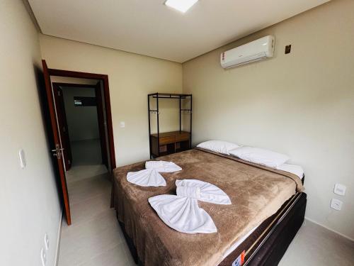 una camera da letto con un letto con due cuscini sopra di Apart Hotel Home Trancoso a Trancoso