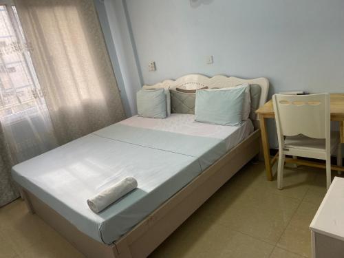 a bed in a room with a table and a chair at Masaki Anne H & Apartment in Dar es Salaam