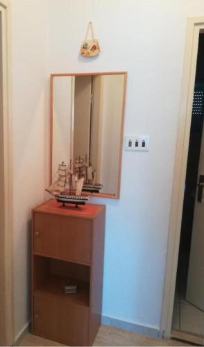 a mirror sitting on top of a wooden dresser at Apartman Volarevic in Donji Karin