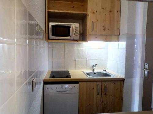 une petite cuisine avec un évier et un micro-ondes dans l'établissement Résidence Dandy - DANDY 077 MAE-4291, à Les Allues