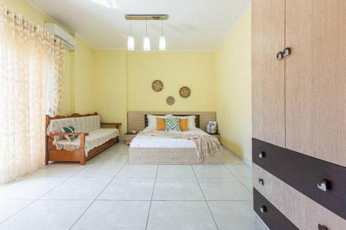 a bedroom with a bed and a couch at Stella's Central - 1min beach, kitchen & balcony in Himare
