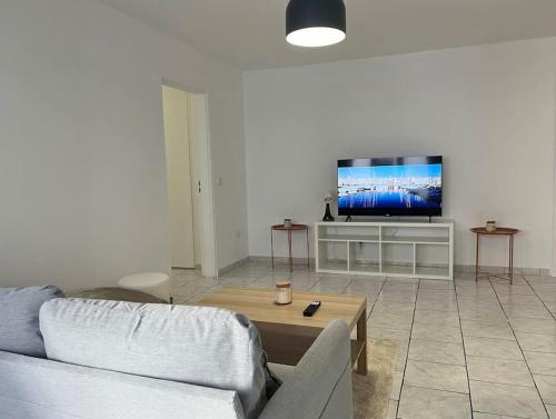 un salon avec un canapé et une télévision à écran plat dans l'établissement Neuf et cosy, 6ème Marseille, à Marseille