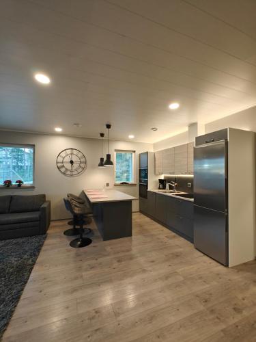 a large kitchen with a refrigerator and a table at Arctic Hill Apartment in Rovaniemi