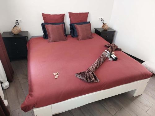 a bedroom with a bed with red sheets and pillows at Vida Verde in Valkenburg